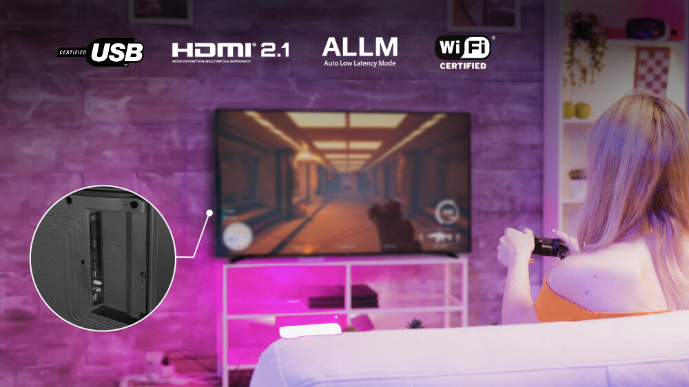 Telewizor JVC LT-50VD3500 - HDMI 2.1 dla graczy, telewizor stojący na stoliku, kadr złącz, kobieta trxzymająca kontroler, siedząca na sofie