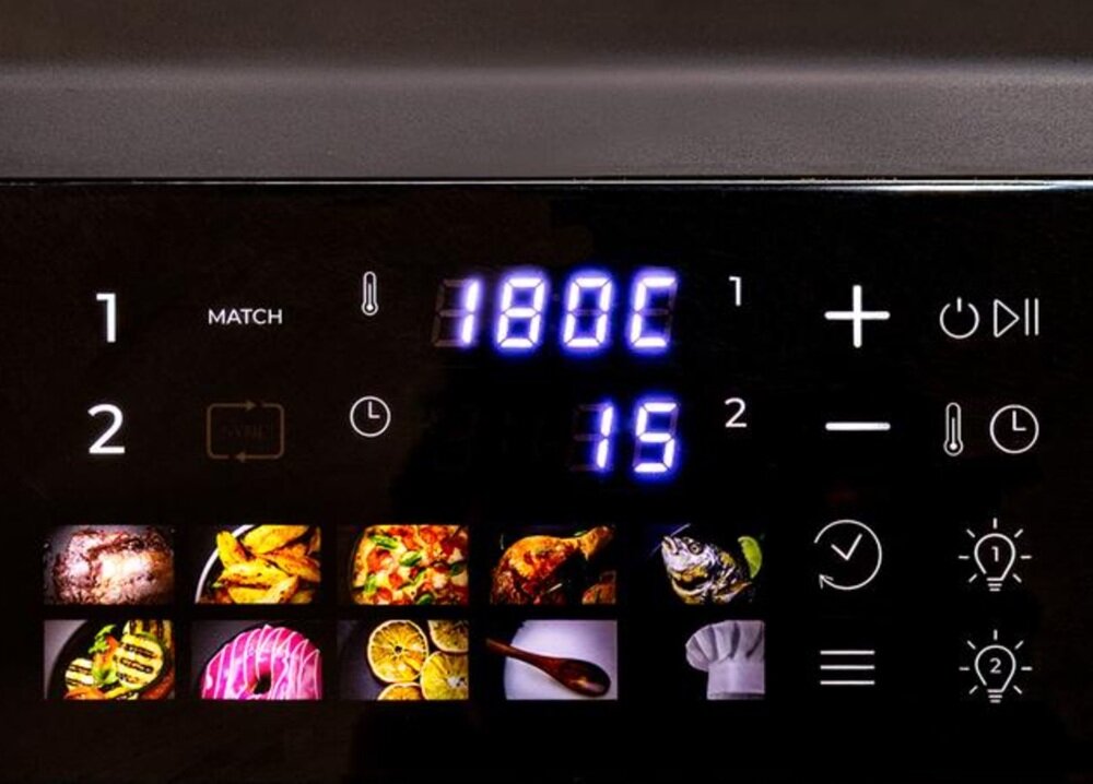 Panel sterowania frytkownicy z wyświetlaczem pokazującym temperaturę 180°C i czas 15 minut. Widoczne są ikony różnych potraw oraz przyciski funkcyjne.
