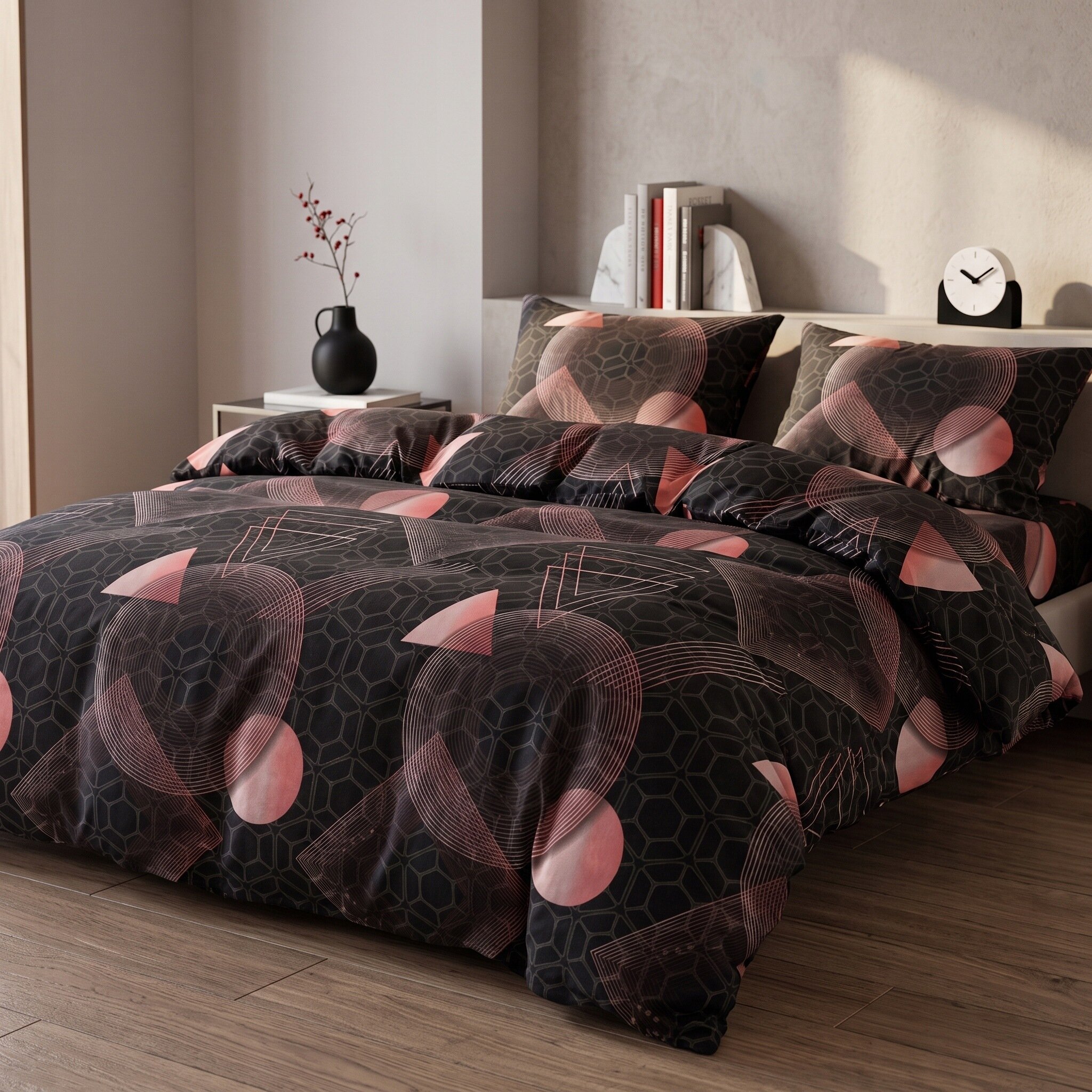Na łóżku znajduje się pościel z geometrycznym wzorem w odcieniach czerni i różu. W tle widać stolik z czarnym wazonem i książkami oraz zegar na półce.