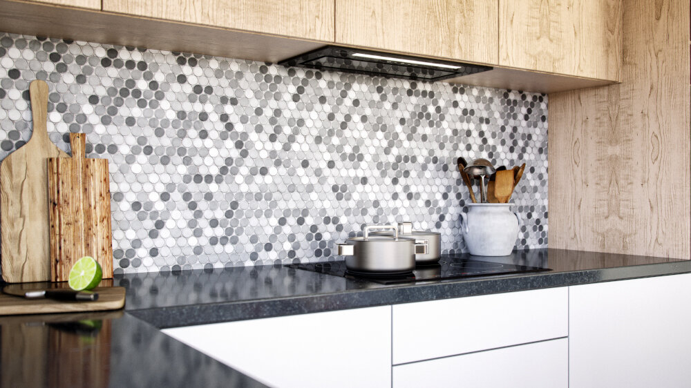 Kuchnia z czarnym blatem, na którym stoi garnek i deski do krojenia. Na ścianie znajduje się mozaika z szarych i białych heksagonalnych płytek, a nad nią zamontowany jest okap.