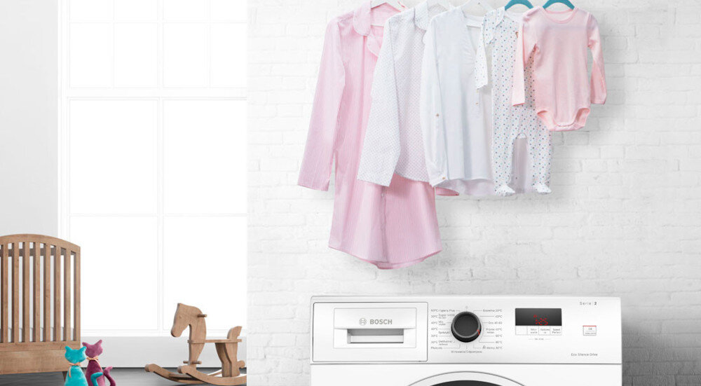 PRALKA BOSCH WGH2460XPL lifestyle pralka front panel wyświetlacz pokój dziecięcy w tle koń na biegunach zabawki dziecięce ubranka na ścianie koszule Higiena Plus eliminacja bakterii zarazków Higienicznie czyste pranie niska temperatura skuteczne komfortowe