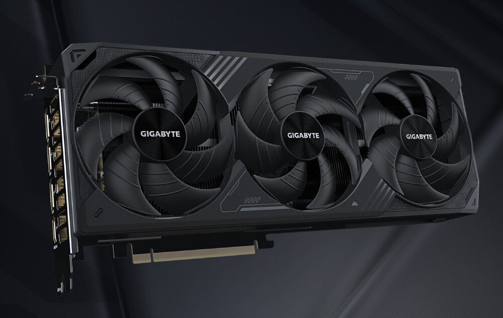 Komputer MAD DOG GeForce RTX5070Ti DLSS 4 Reflex Edition 2 DEEPCOOL-A22DR64 Widok karty graficznej z trzema dużymi wentylatorami chłodzącymi, logo 'Gigabyte' na każdym z nich, z boku widoczne złącza wideo, karta graficzna, architektura, rdzenie CUDA, wentylatory