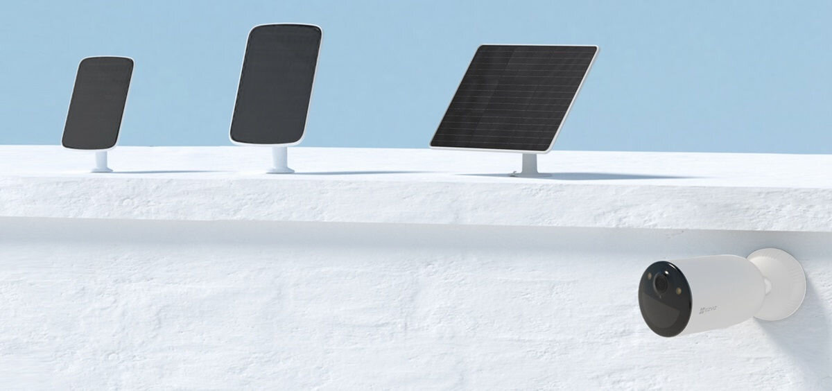 Kamera EZVIZ CB3 Zewnętrzna, Wi-Fi, pojemny, akumulator, podłączenie, panel, Trzy różne panele słoneczne i kamera EZVIZ zamontowana na białym tle pod błękitnym niebem