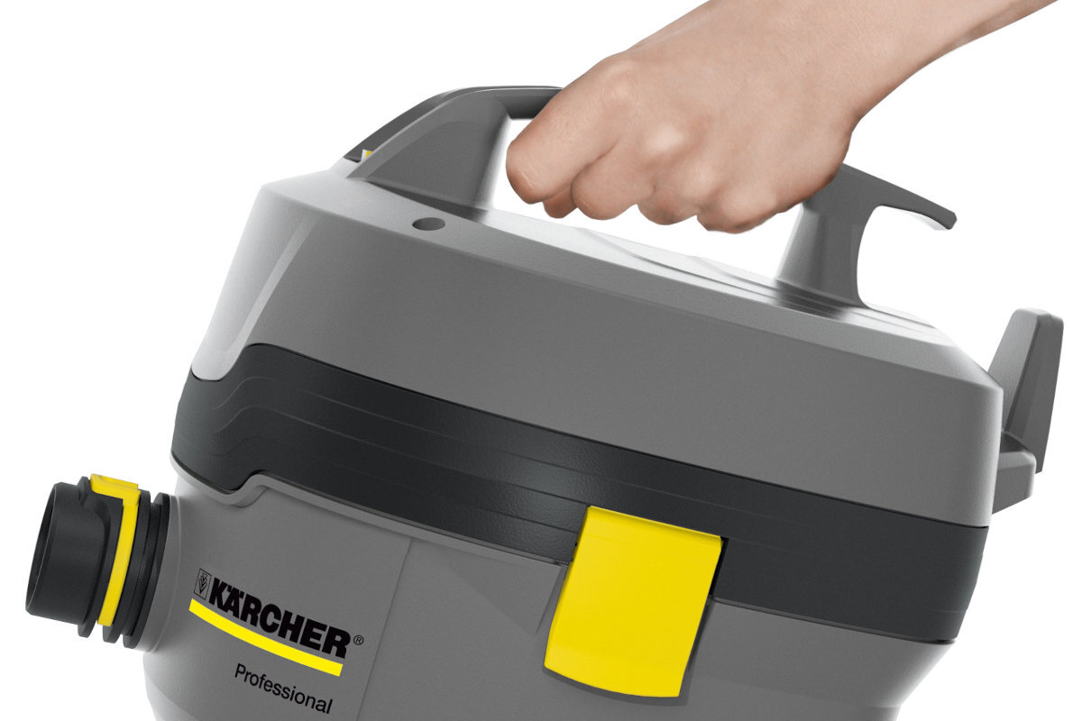 Szara obudowa odkurzacza z czarnymi i żółtymi elementami, trzymana za uchwyt przez rękę. Widoczne logo \'KARCHER Professional\'.