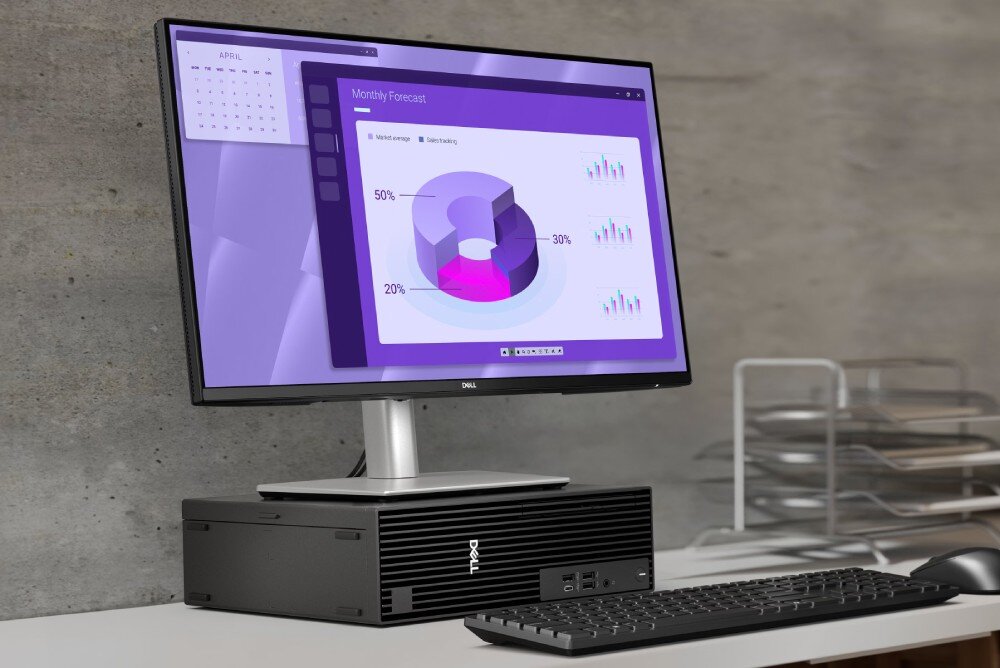 Komputer DELL Pro Slim Plus QBS1250 Czarny komputer stacjonarny leżący poziomo na biurku, służący jako podstawka pod monitor z wyświetlonymi kolorowymi wykresami kołowymi, pamięć RAM, rozbudowa, dysk