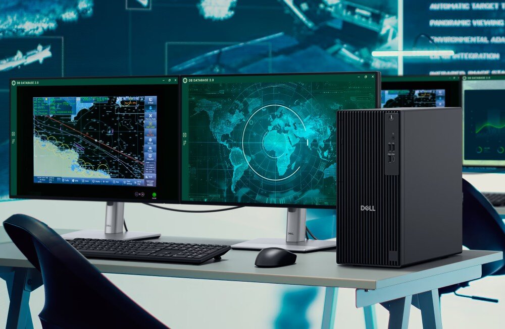Komputer DELL Pro Tower QCT1250 biuro z dwoma stanowiskami komputerowymi ustawionymi przy długim drewnianym blacie. Na monitorach widoczne są kalendarze oraz kolorowe wykresy kołowe z danymi procentowymi, zabezpieczenia, funkcje, zarządzanie