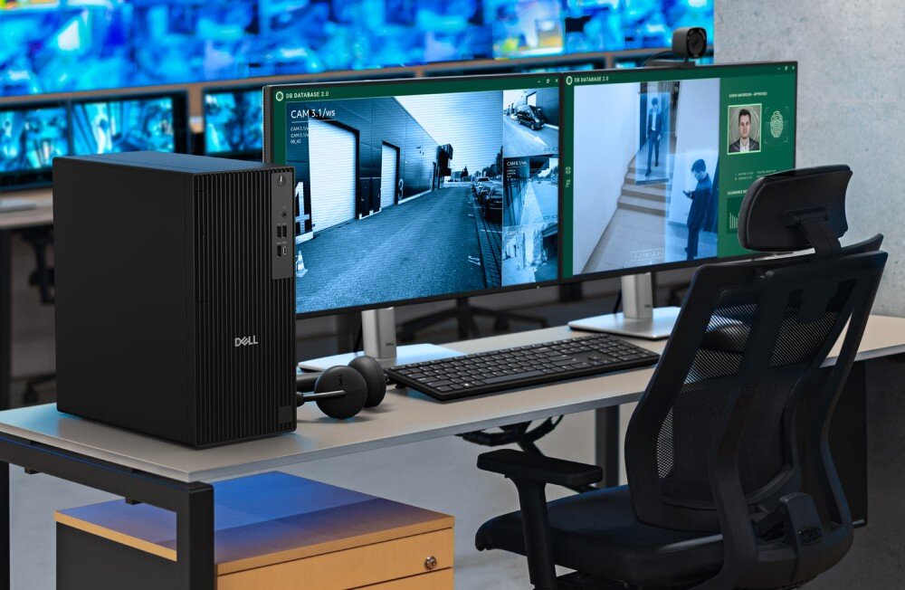 Komputer DELL Pro Tower QCT1250 Komputer stacjonarny i monitor stojące na biurku przy oknie z widokiem na miasto. Na ekranie widoczny jest projekt architektoniczny nowoczesnego domu z zielonym napisem 'CONFIDENTIAL', BIOS