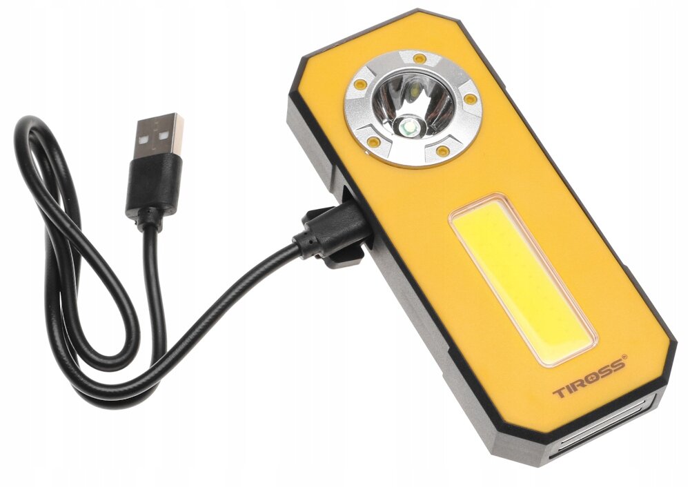 Na obrazie znajduje się żółta latarka warsztatowa z wbudowanym panelem LED i okrągłym reflektorem, podłączona do kabla USB. Na obudowie widoczne jest logo \'TIROSS\'.