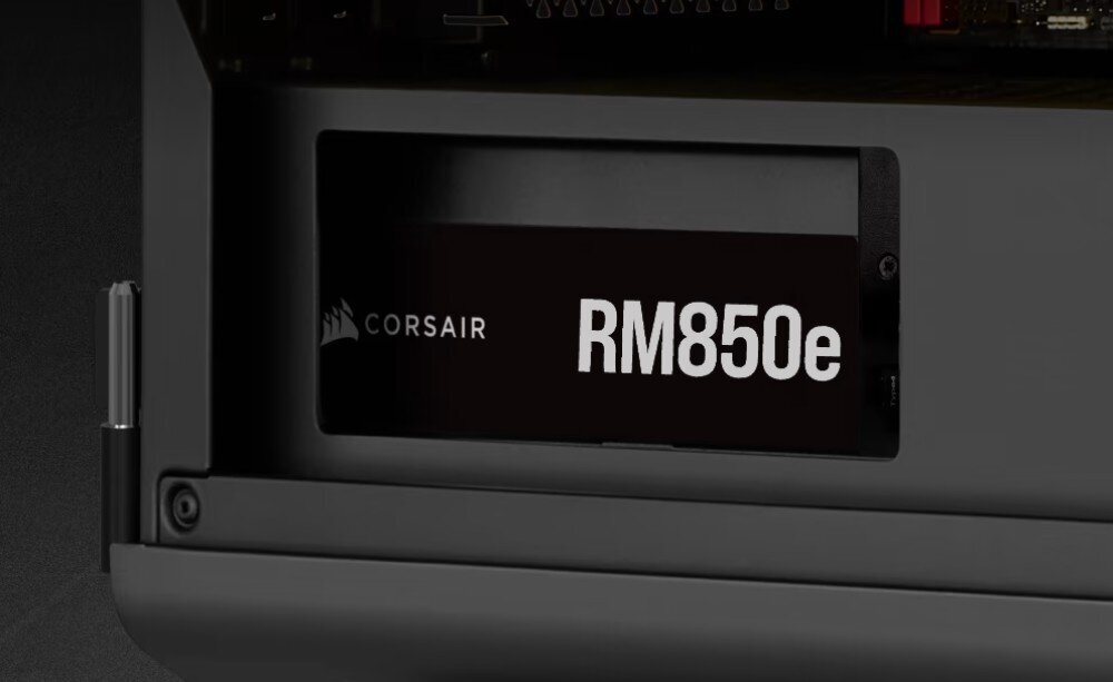 Komputer MAD DOG CORSAIR4000-A01WD32 Zasilacz komputerowy wewnątrz obudowy z widocznym napisem 'Corsair RM850e' na czarnym panelu bocznym, zasilacz, moc, sprawność, certyfikat, zasilacz, moc, sprawność, certyfikat, topologia LLC