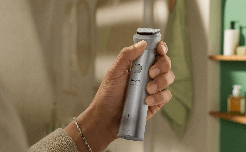 Mężczyzna trzyma w ręce urządzenie multigroom