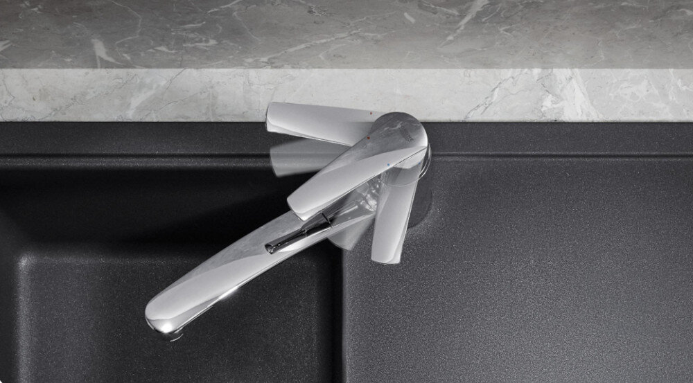 Zlewozmywak jednokomorowy z ociekaczem GROHE K200 31565SD1 Stal szlachetna 50x86 + bateria stojąca Eurosmart 3328100311 Na zdjęciu w zbliżeniu widać chromowaną baterię kuchenną GROHE, której dźwignia regulacyjna jest płynnie odchylana dłonią. Rozmyte kontury uchwytu w kilku pozycjach podkreślają lekkość sterowania strumieniem i temperaturą wody GROHE SilkMove ceramiczna głowica precyzyjna regulacja strumienia wody niezawodność trwałość komfort użytkowania 20 lat bezawaryjność codzienna wygoda