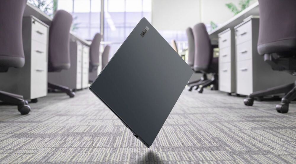 Laptop ACER TravelMate P4 16 TravelMate z wytrzymałą obudową unosi się nad podłogą biurową, prezentując konstrukcję do codziennej pracy biznesowej.