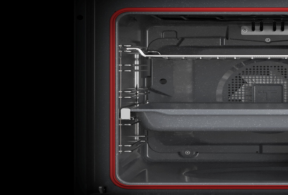 Piekarnik TEKA NEO HSB 6350 SS Zdjęcie przedstawia wnętrze piekarnika z wysuniętą blachą i widoczną czerwoną uszczelką, otoczone metalowymi prowadnicami i elementami konstrukcyjnymi ścian komory. Całość utrzymana jest w ciemnej kolorystyce, podkreślającej charakter urządzenia emalia BrightClean łatwe czyszczenie intensywne gotowanie powłoka trwałość