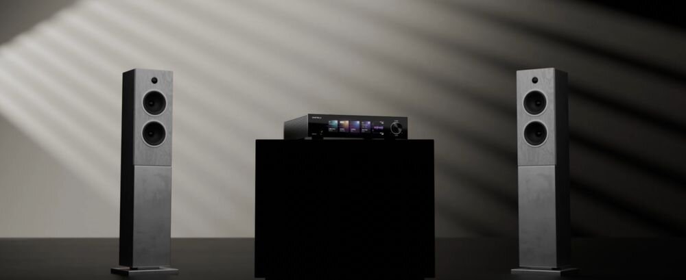 Przetwornik cyfrowo analogowy EVERSOLO DAC-Z10 hi fi precyzyjne brzmienie wysoka rozdzielczość audio, przetwornik stojący na postumencie obok dwóch kolumn głośnikowych w ciemnym pokoju