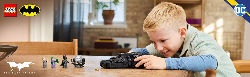 Dziecko bawi się modelem pojazdu z klocków LEGO na stole, obok znajdują się figurki postaci. W lewym górnym rogu widoczne są loga LEGO, Batman i DC, a na dole napis \'The Dark Knight\'.