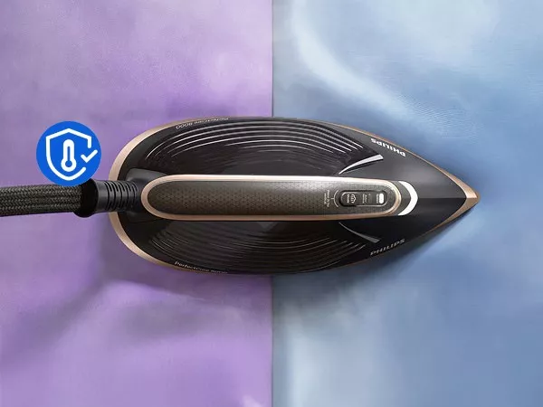 Zdjęcie przedstawia żelazko z widocznym logo PHILIPS na stopie, leżące na dwukolorowej powierzchni w odcieniach fioletu i niebieskiego. Obok znajduje się niebieska ikona z symbolem termometru i haczykiem.