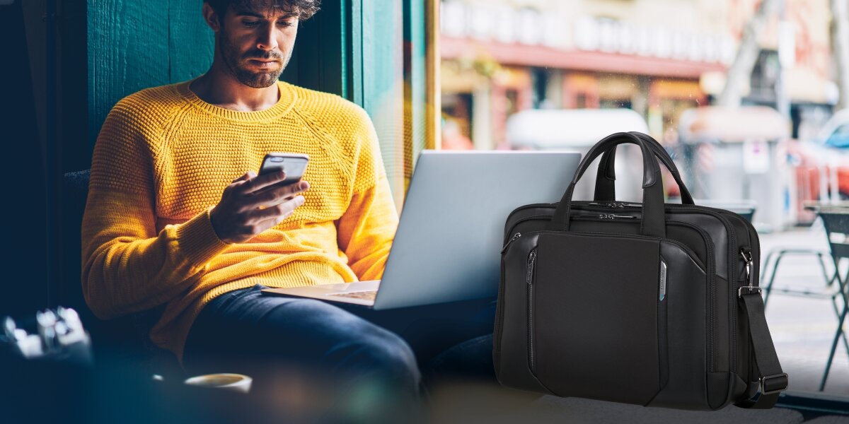 Praktyczna torba biznesowa, osoba z laptopem na kolanach obok torby