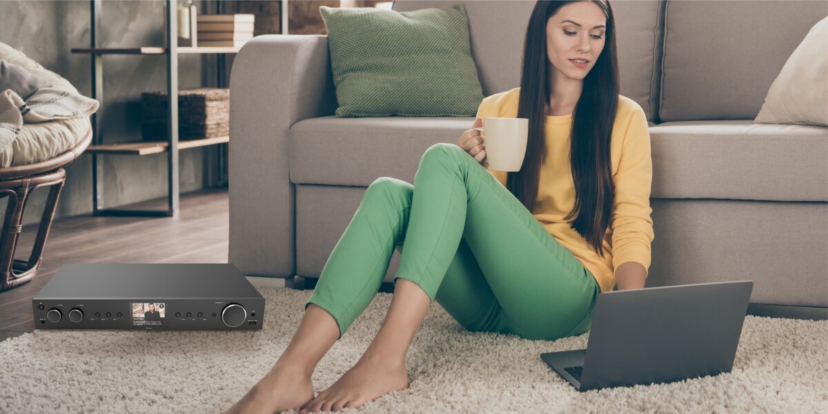 Tuner HAMA DIT2105 - Sterowanie z aplikacji OKTIV, Wi-Fi, osoba siedząca na ziemi przy laptopie oraz tunerze