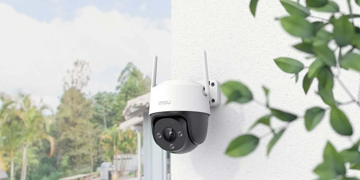 Kamera IMOU Cruiser SE 2MP Zewnętrzna, Wi-Fi, dopasowane, zapisanie, nagrania, microsd, kamera zamontowana do ściany budynku w tle roślinność