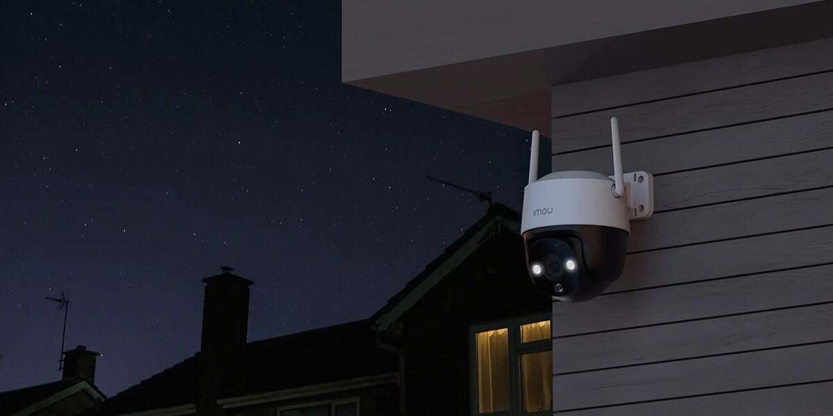Kamera IMOU Cruiser SE 2MP Zewnętrzna, Wi-Fi, sparować, aplikacja, alerty, powiadomienia, kamera zamontowana do ściany budynku nocną porą, w tle dom