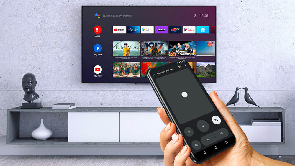 Odtwarzacz multimedialny 4K TESLA MediaBox XA400 Android TV Google Play YouTube Netflix, telewizor zawieszony na ścianie , ręka trzymająca smartfona