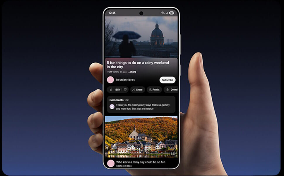Osoba trzyma smartfon z wyświetlonym ekranem, na którym widać aplikację z filmem o tematyce deszczowego weekendu w mieście. Na ekranie widoczny jest tekst: \'5 fun things to do on a rainy weekend in the city\' oraz komentarze użytkowników.