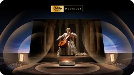 Obraz przedstawia projektor wyświetlający scenę z osobą grającą na instrumencie smyczkowym w otoczeniu kolumn. Na górze widoczne jest logo \'OPERA DE PARIS DEVIALET\'.