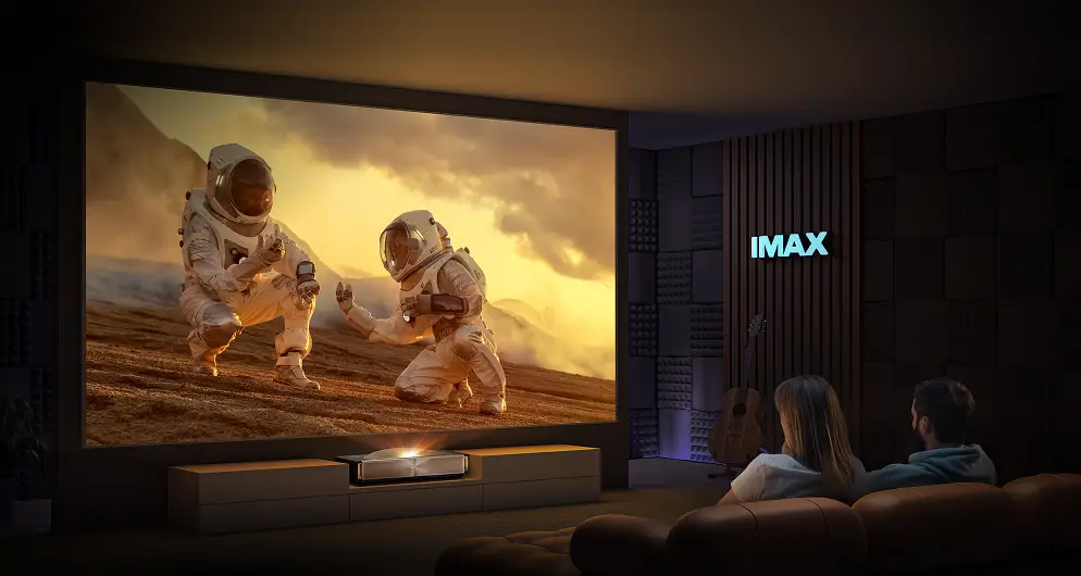 Projektor wyświetla na dużym ekranie film z astronautami oglądany przez parę na kanapie, na ścianie logo IMAX.