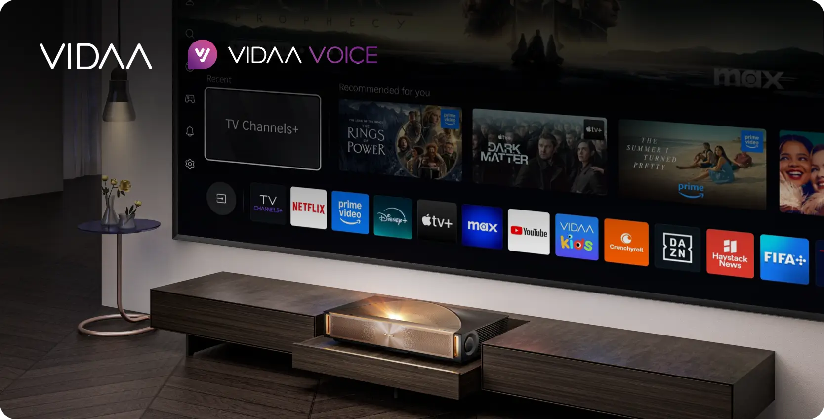 Projektor i ekran z interfejsem VIDAA i VIDAA VOICE, pokazujący kafelki oraz ikony wielu aplikacji multimedialnych.