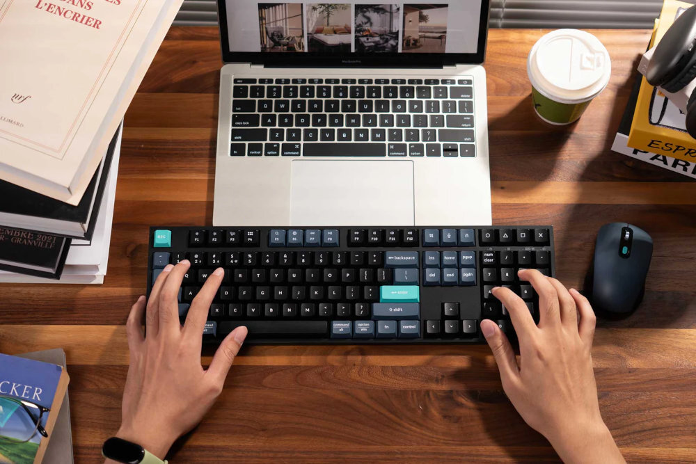 Zestaw KEYCHRON Wireless Combo KCBD2 wygodzie i ergonomii Mysz BM25 79 g 110 × 89 × 40 mm Klawiatura B36 650 g - ręce na klawiaturze obok laptopa