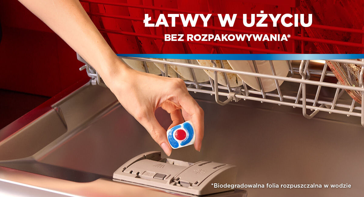 Zbliżenie na dłoń wkładającą kapsułkę Somat bezpośrednio do dozownika zmywarki. Napis: Łatwy w użyciu bez rozpakowywania. Na dole informacja o biodegradowalnej folii rozpuszczalnej w wodzie.