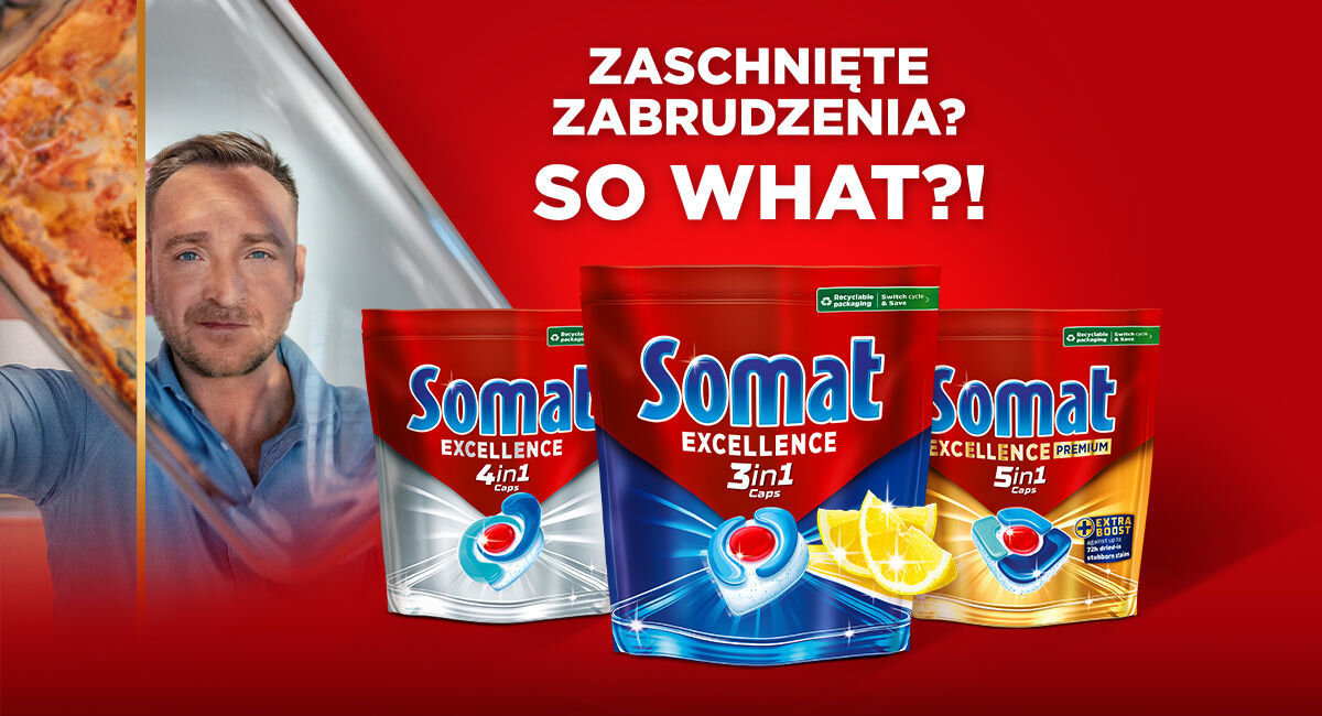 Grafika reklamowa na czerwonym tle prezentująca trzy opakowania kapsułek Somat Excellence. Wariant 3in1 wyróżniony grafiką plastrów cytryny. Obok mężczyzna prezentujący czyste szklane naczynie. Napis: Zaschnięte zabrudzenia? So what?!.