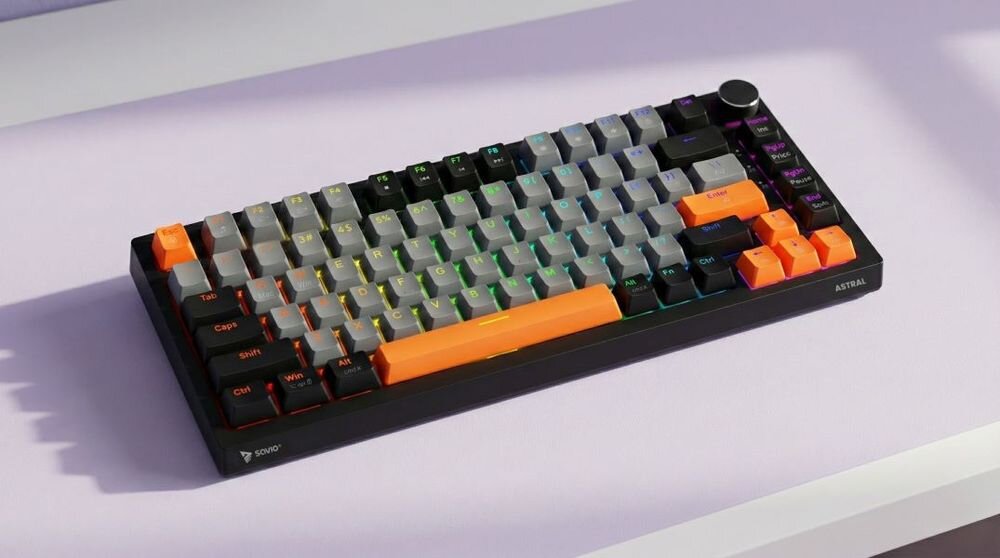 Klawiatura mechaniczna z czarno-szaro-pomarańczowymi klawiszami, z podświetleniem RGB. Na obudowie widoczne są napisy \'SAVIO\' i \'ASTRAL\'.