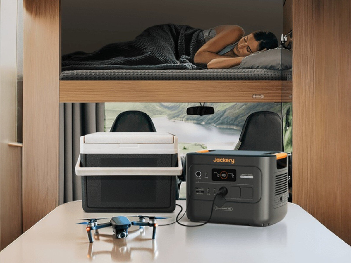 Stacja zasilania JACKERY Explorer 3000 V2 EU 3072 Wh Bank energii, UPS, cisza, 27dB, blackout, kobieta śpi na piętrze w kamperze, na pierwszym planie pracujący zasilacz