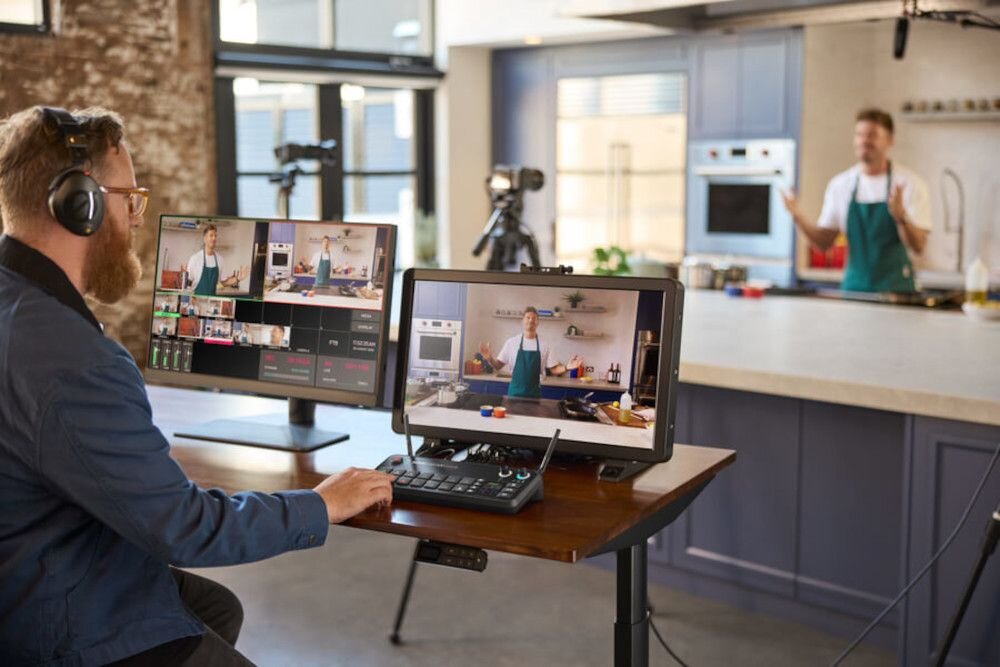 Mikser audio RODE Rodecaster Video - streamowanie, mezczyna przed ekranem monitora, mikser na biurku, scena, przyciski funkcjonalnosc