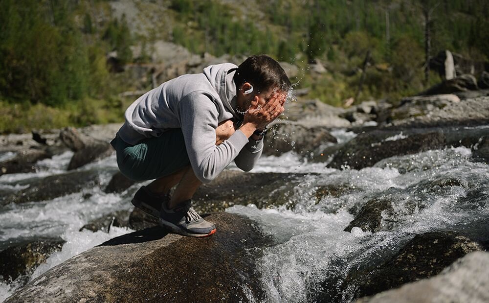 Słuchawki dokanałowe JBL Endurance Peak 4 IP68 odporność woda pył sport trening plener, osoba z założonymi słuchawkami