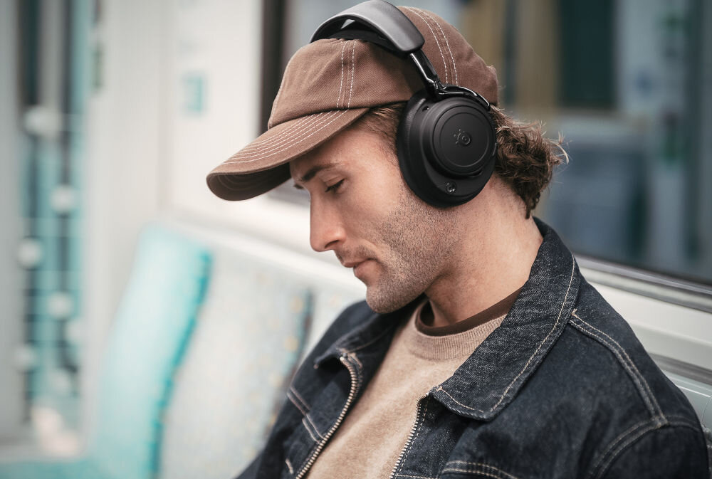 Słuchawki STEELSERIES Arctis Nova Elite OmniPlay łączność PC PlayStation Xbox Switch, osoba z założonymi słuchawkami nausznymi