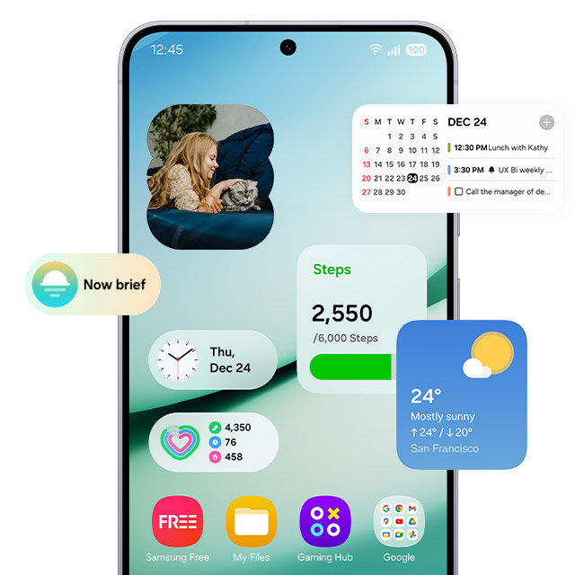 Na ekranie smartfona wyświetlane są widżety i powiadomienia. Kalendarz z wydarzeniami na 24 grudnia, widżet pogodowy pokazujący pogodę w San Francisco, licznik kroków oraz ikony aplikacji, takich jak Samsung Free, Pliki i Gaming Hub. Na ekranie smartfona wyświetlane są widżety i powiadomienia. Kalendarz z wydarzeniami na 24 grudnia, widżet pogodowy pokazujący pogodę w San Francisco, licznik kroków oraz ikony aplikacji, takich jak Samsung Free, Pliki i Gaming Hub.