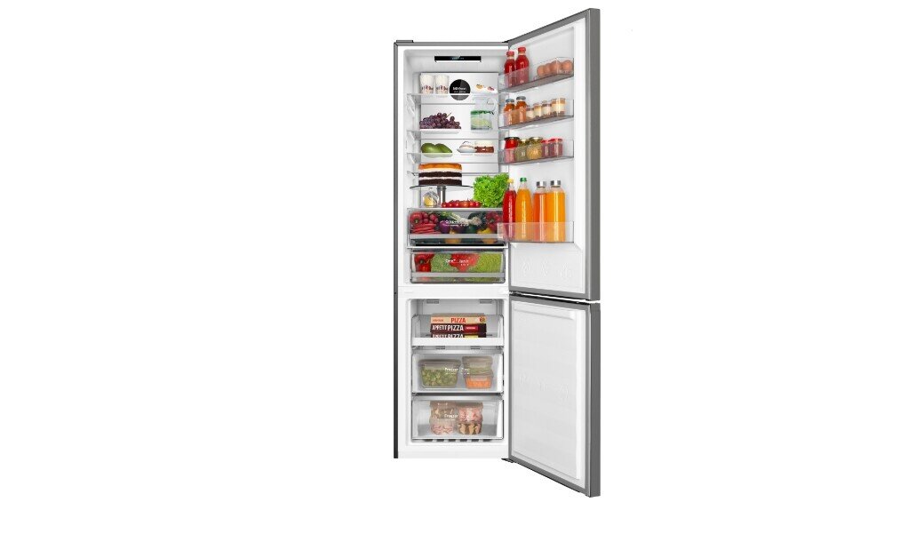 Otwarta lodówka z widocznymi półkami wypełnionymi różnorodnymi produktami spożywczymi, takimi jak owoce, warzywa, napoje i pudełka z jedzeniem. Drzwi lodówki również zawierają kilka butelek i słoików.