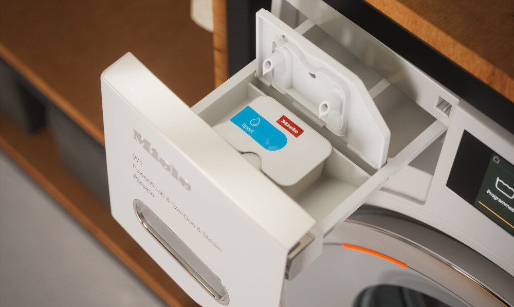 PRALKA MIELE W1 WWA120 WCS zdjęcie lifestyle wysunięta otwarta szuflada komory na detergenty Dozowanie w porcjach CapDosing ImpraProtect Booster do uporczywych plam lub CottonRepair Kapsułki z recyklingu precyzyjne dozowanie