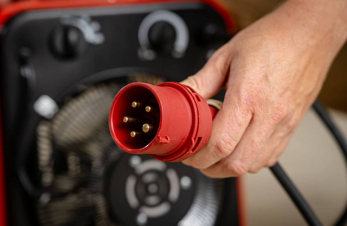 Nagrzewnica elektryczna DEDRA DED9922B, 400V, trójfazowy, stabilność, ciągłość, Czerwona wtyczka trójfazowa 400 V – zbliżenie na podłączenie zasilania do nagrzewnicy DED9922B.
