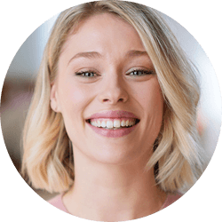 Kobieta uśmiecha się, ukazując zęby.