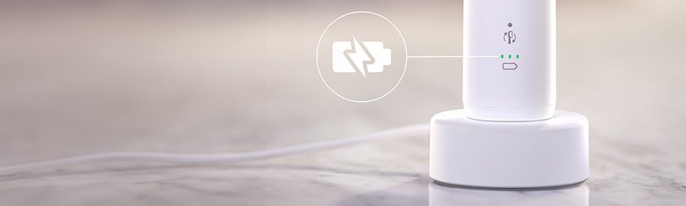 Szczoteczka podłaczona do ładowarki. Zbliżenie na ikonę baterii.