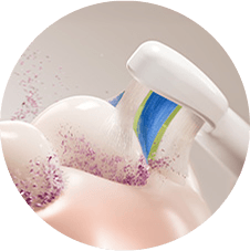 Zbliżenie na szczoteczkę usuwającą z zębów rozbitą płytkę.