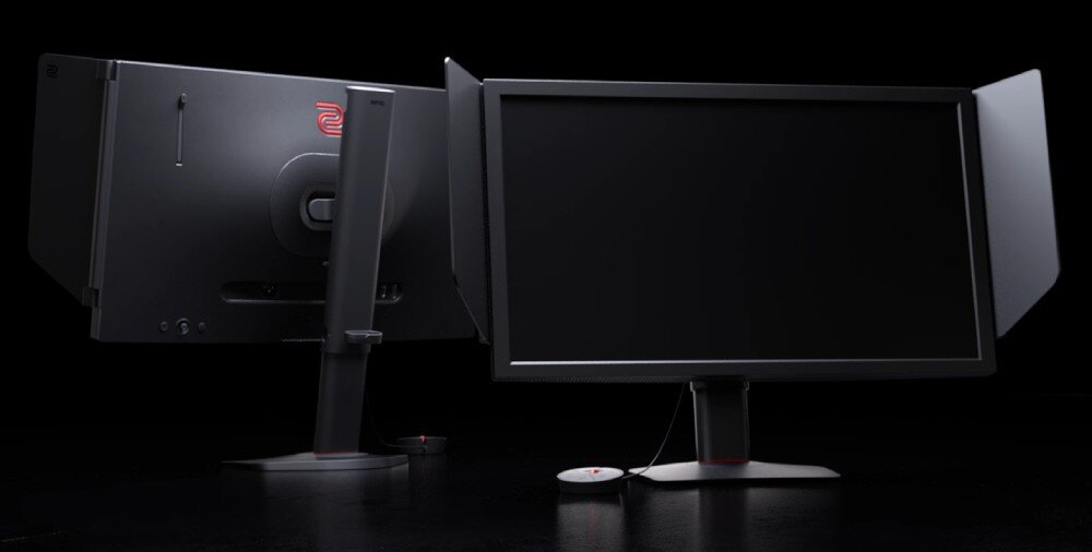 Monitor BENQ XL2566X+ Monitor z serii XL ustawiony przodem i tyłem, widoczne boczne osłony ekranu oraz okrągły kontroler na kablu leżący na podstawie, opis