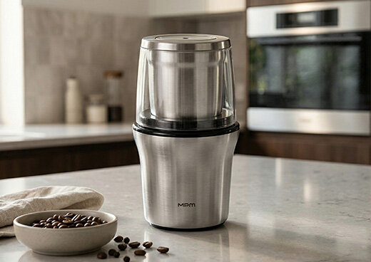 Młynek i rozdrabniacz 2w1 MMK-06M na blacie kuchennym, obok ziarna kawy w misce i na blacie.