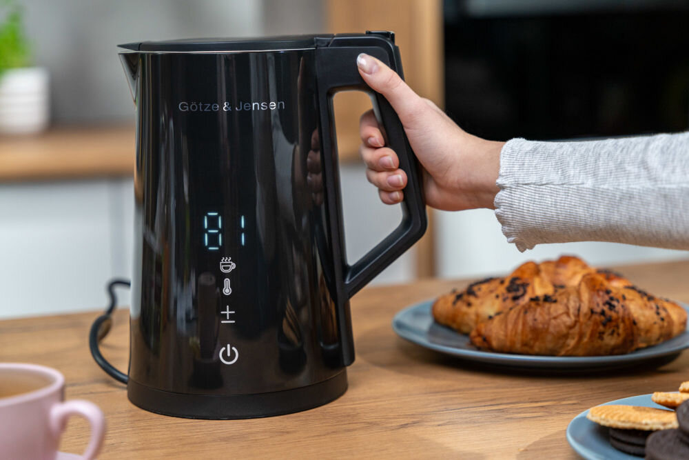 CZAJNIK GÖTZE&JENSEN KT975K (DOUBLE WALL) (WI-FI) (1,7L) osoba podnosząca czajnik z podstawy utrzymywanie temperatury podwójne ścianki bezpieczeństwo bez nagrzewania się obudowy