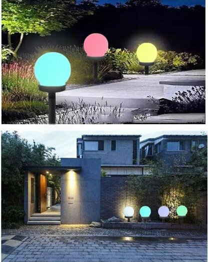 Obraz przedstawia kilka lamp solarnych ogrodowych w kształcie kul, świecących różnymi kolorami: niebieskim, różowym, żółtym i białym. Lampy są umieszczone w ogrodzie oraz przy wejściu do nowoczesnego budynku.