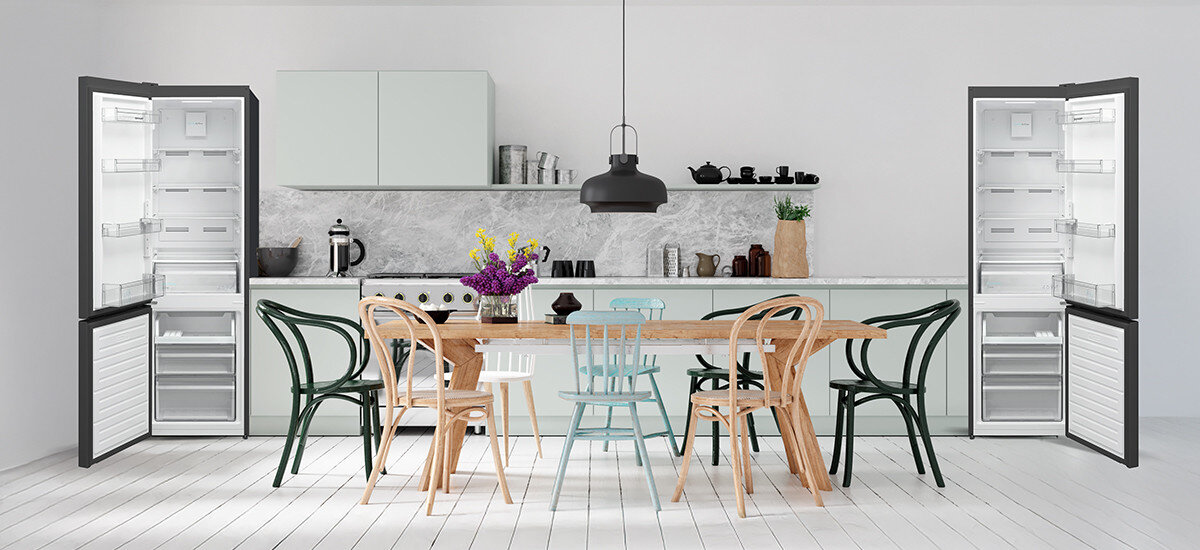 LODÓWKA SHARP SJ-FBA05DHXBE-EU W kuchni ustawiono dwie otwarte lodówki po obu stronach stołu, co prezentuje możliwości aranżacyjne i przejrzystą organizację wnętrza. Jasne tło i symetryczny układ nadają scenie harmonii zmiana kierunku otwierania elastyczne ustawienie dopasowanie do kuchni wygodny dostęp funkcjonalność