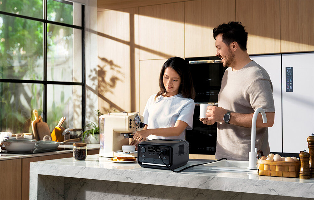 Stacja zasilania ECOFLOW River 3 Plus 286 Wh kuchnia dwie osoby robią kawę stacja na blacie kuchennym aplikacja mobilna EcoFlow monitoring dostosowywnie ustawień powiadomienia na system Android i iOS